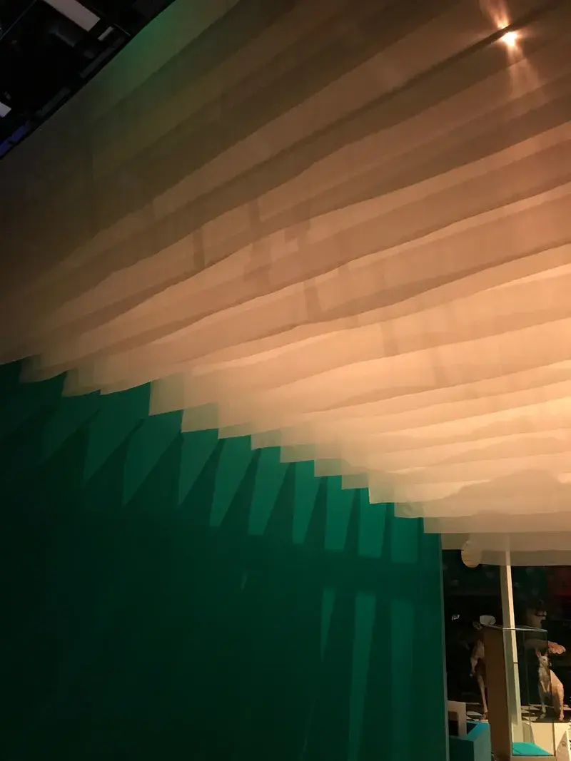 Layered sheer voile valance against a coloured gallery wall