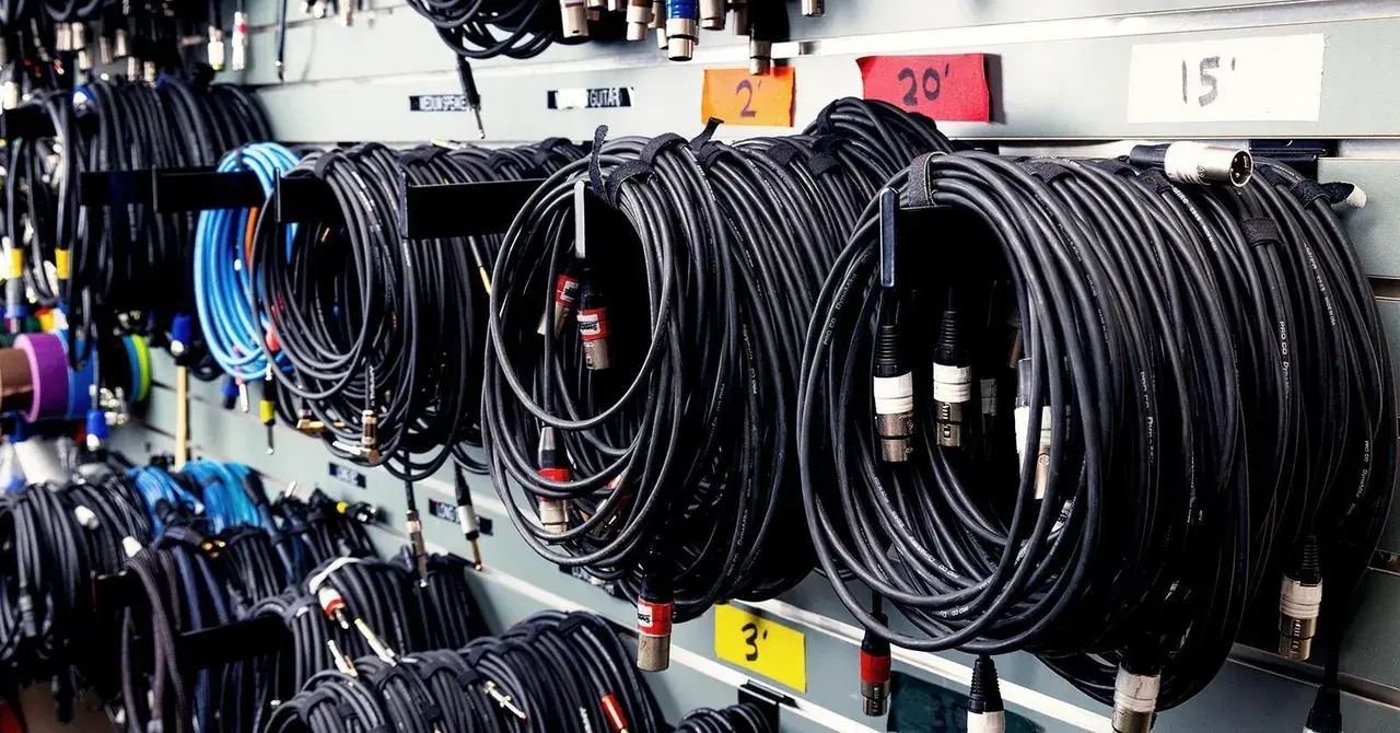 Stage cabling dressed and managed off the deck, with leads coiled and run clear of crossovers rather than loose across the floor.