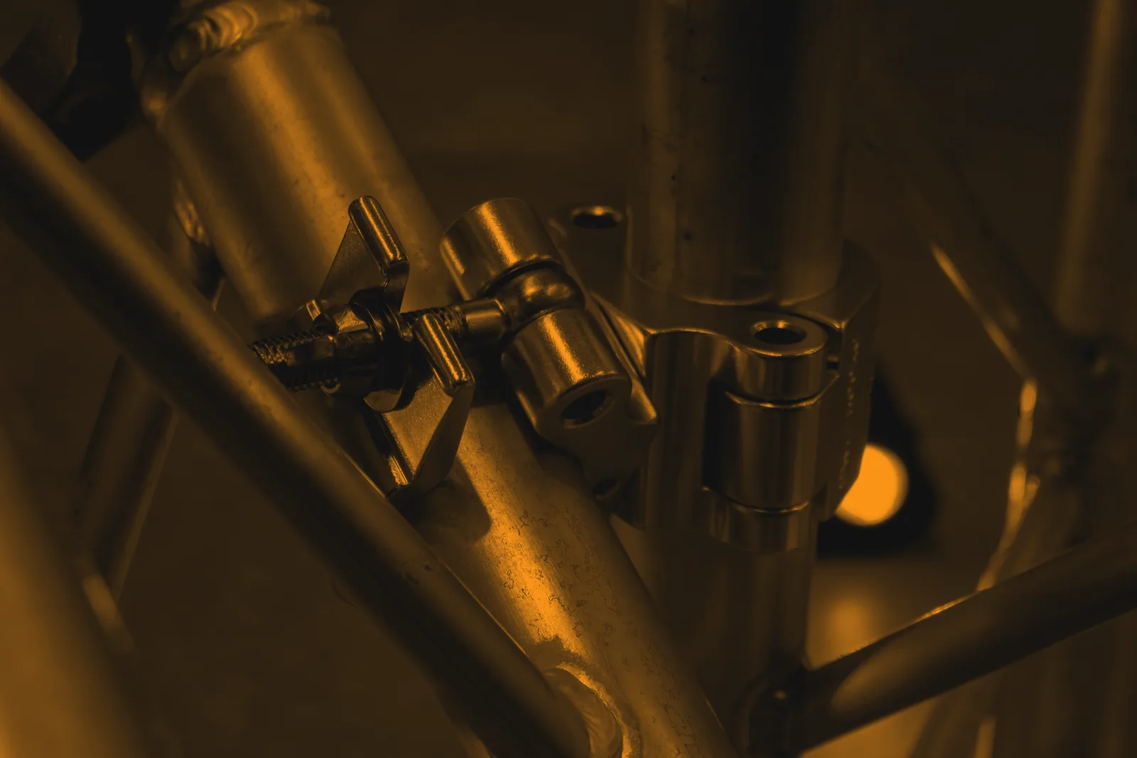 Swivel coupler joining two tubes off-square, the central pin rotating between the two jaws