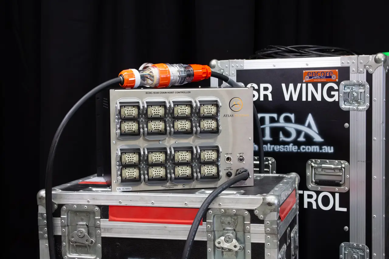 Atlas ECHC-16 chain hoist controller with sixteen output sockets sitting on a TSA flight case, mains lead plugged in.