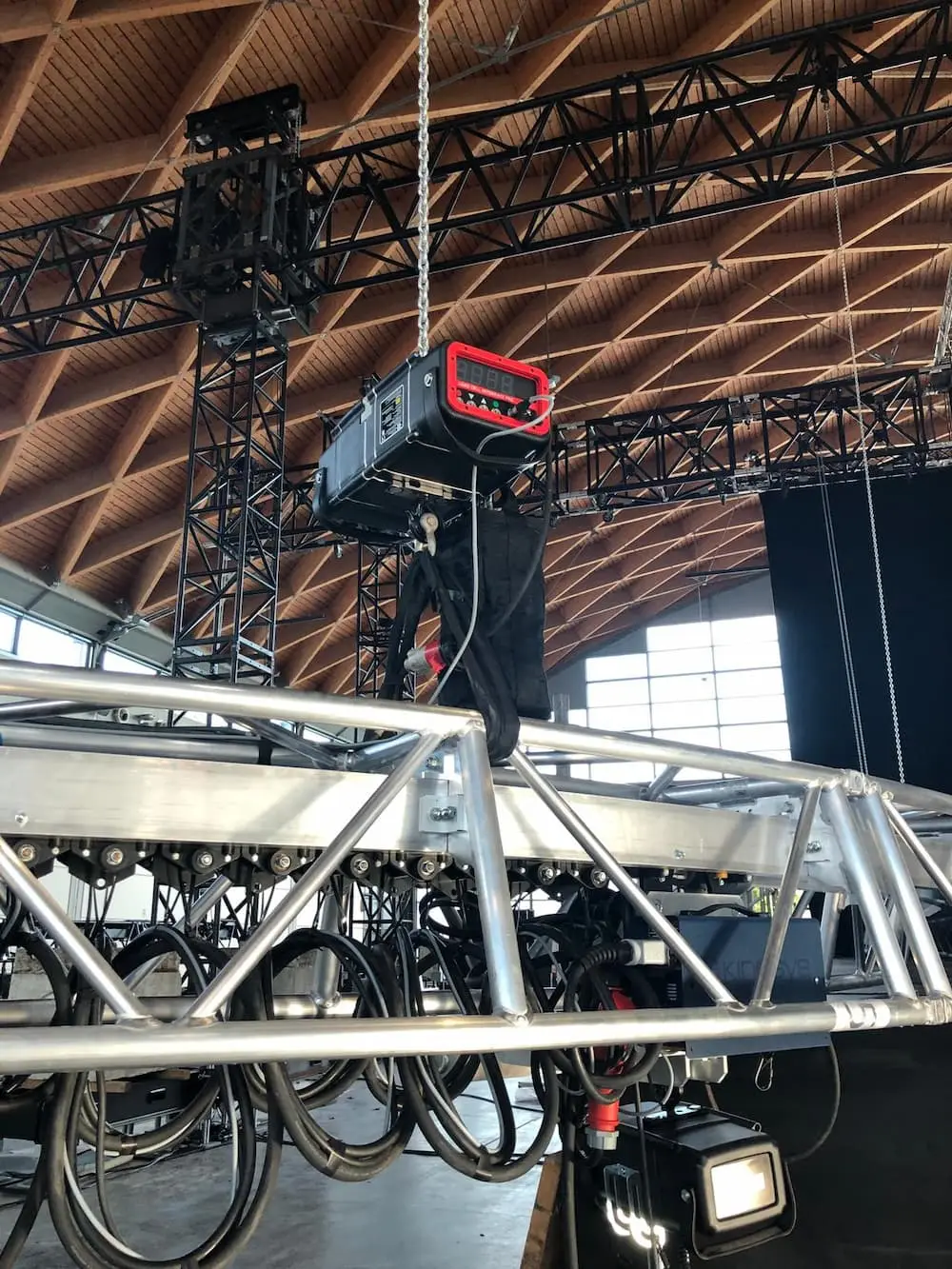 Chain hoist with digital loadcell readout rigged from truss inside a large arched-roof venue