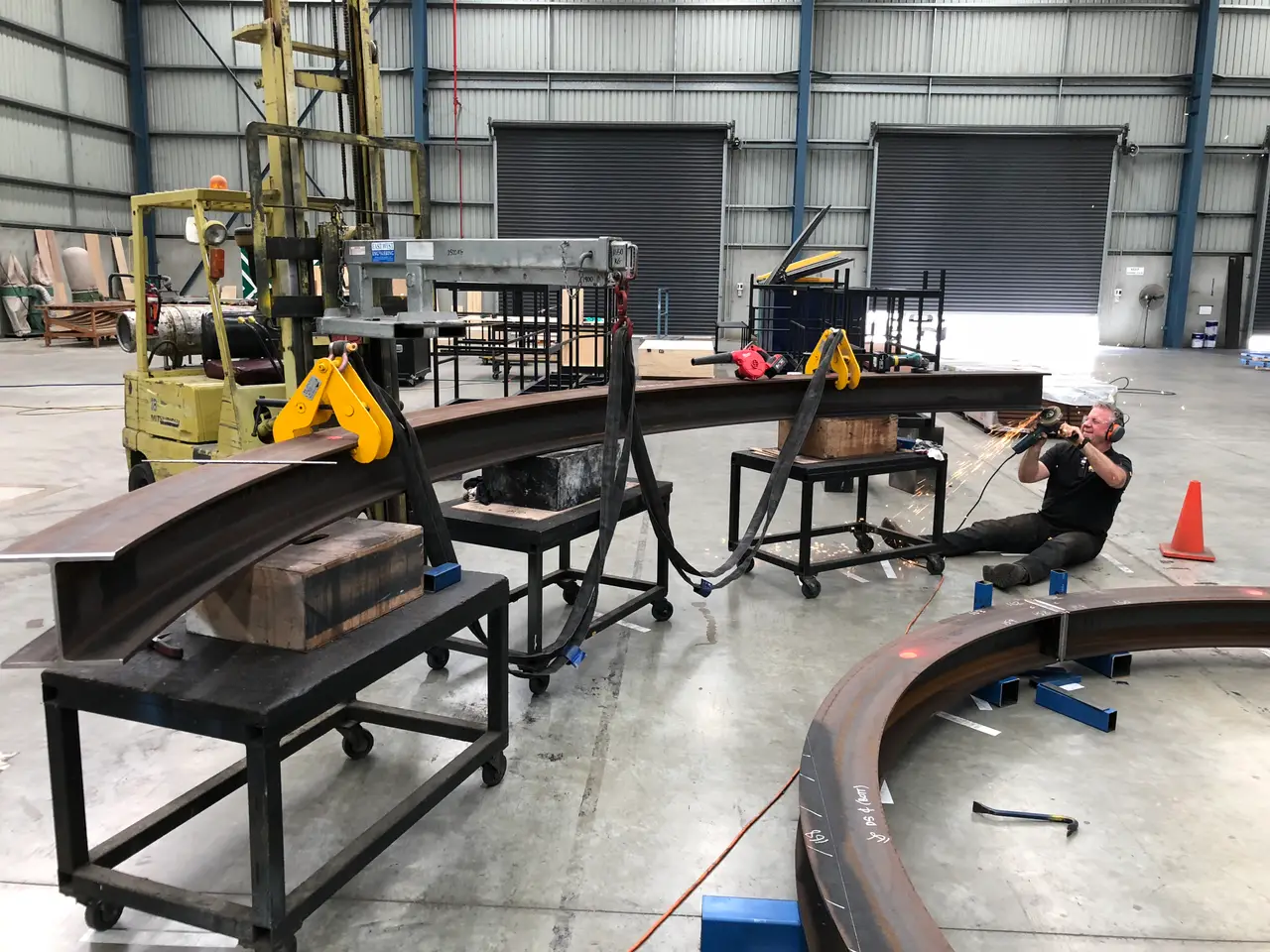 Curved steel revolve track sections being welded and fitted in the workshop
