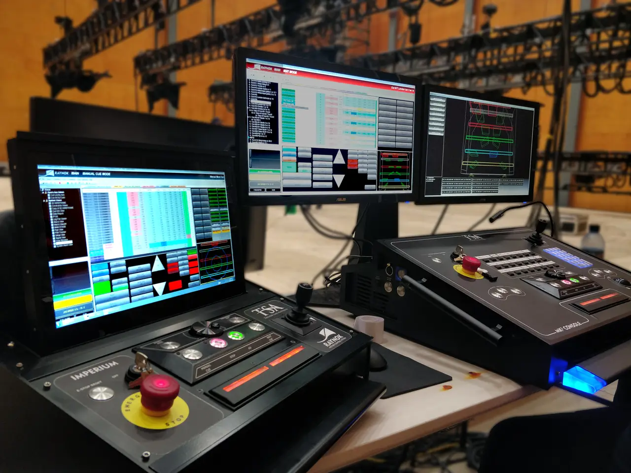 Dual Raynok Imperium control consoles with cue-list and CAD screens, truss rig behind