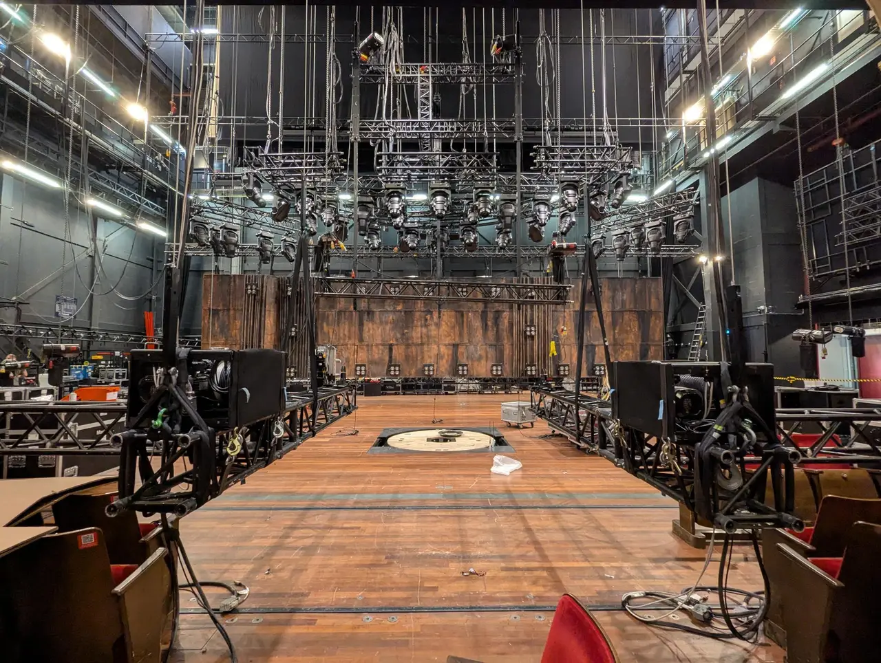 Empty stage with overhead lighting truss grid and a central revolve turntable