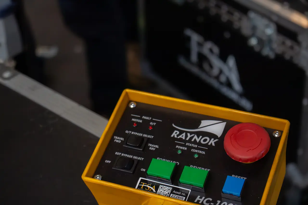 Macro shot of a yellow Raynok HC-100 hoist controller with red emergency stop