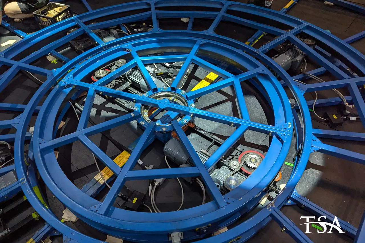 Overhead view of a large blue stage revolve mechanism under fabrication