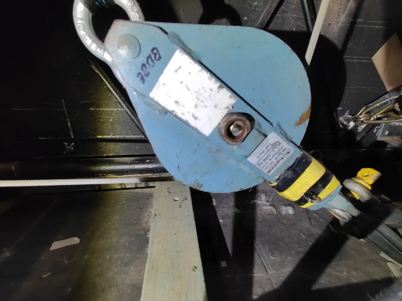 A blue pulley block with its WLL tag, rigged in a fly tower at the Electric Theatre.