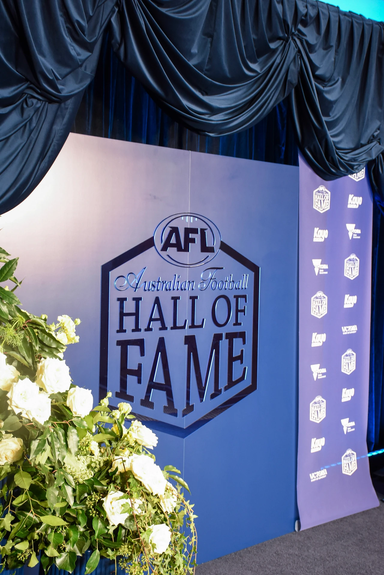 Hall of Fame logo wall with velvet swag header and a lilac side panel of premiership emblems