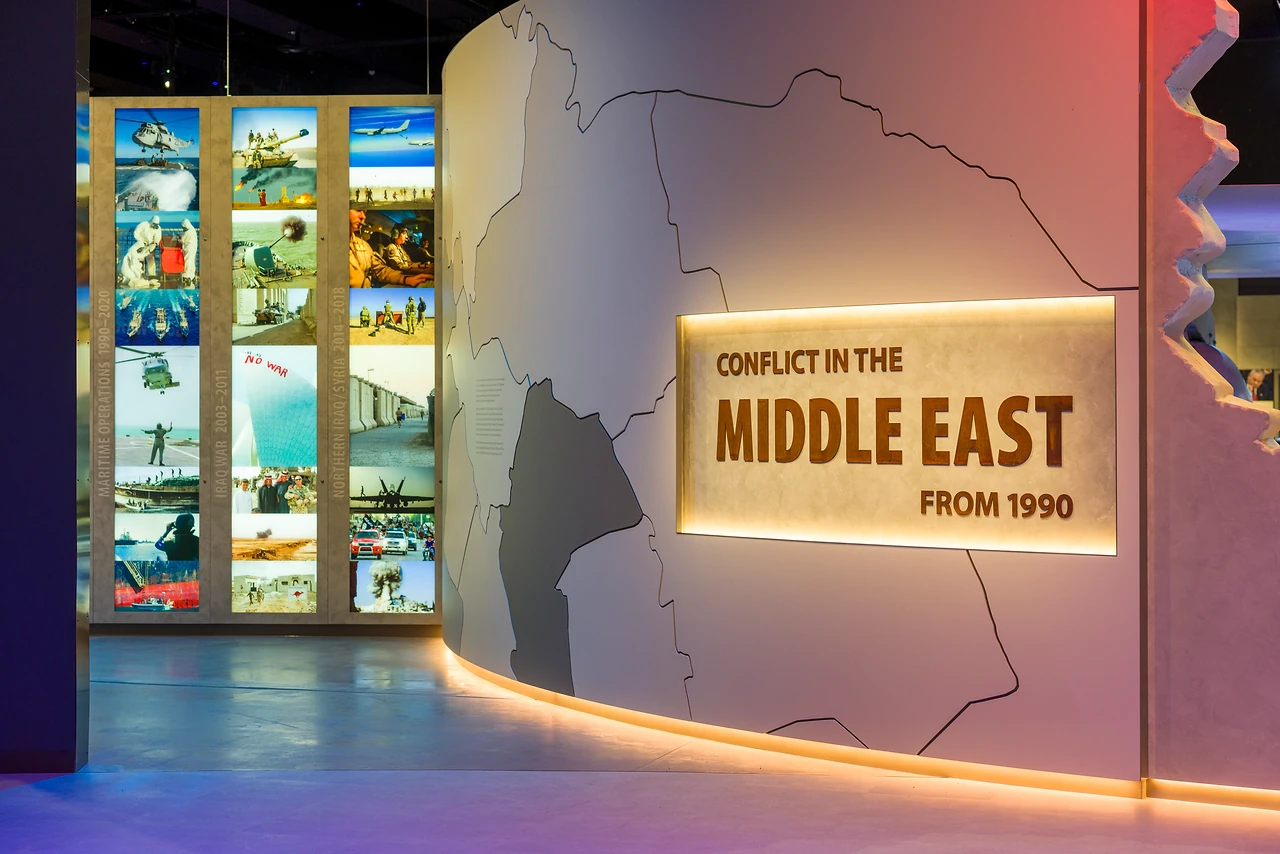 Illuminated photo columns beside a curved Middle East map wall with glowing heading