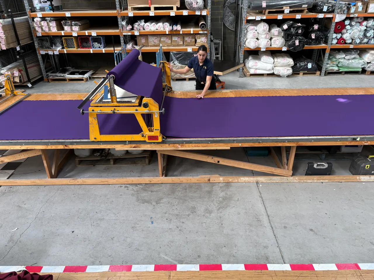 Purple cloth for the Come Alive roof swags rolled out along the workshop cutting table