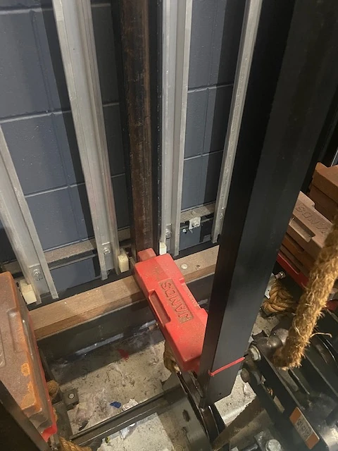 Red block beside the counterweight guide with weights and a rope lock