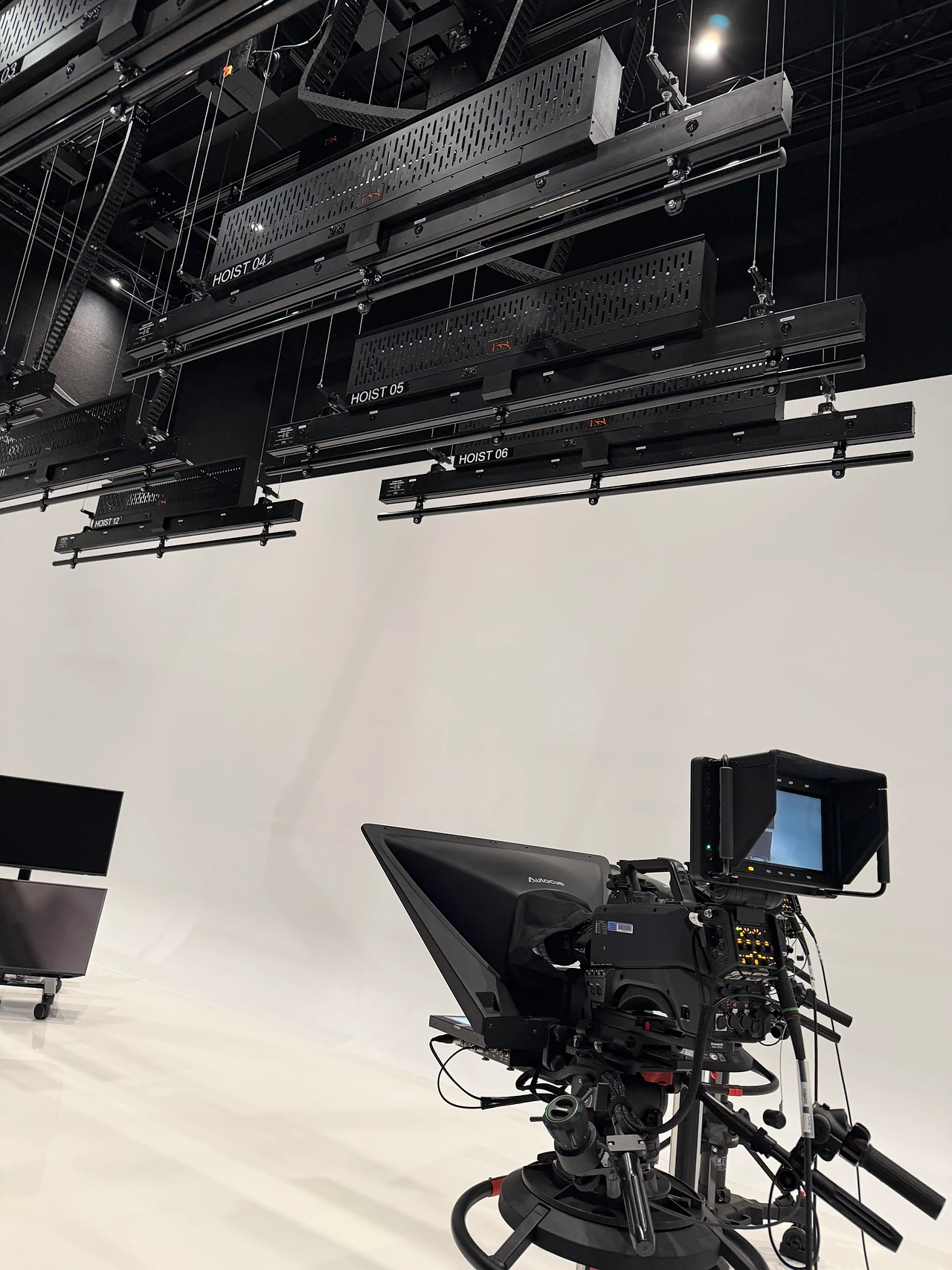 Studio camera and teleprompter beneath the TSA hoist bars at ECU City Campus.
