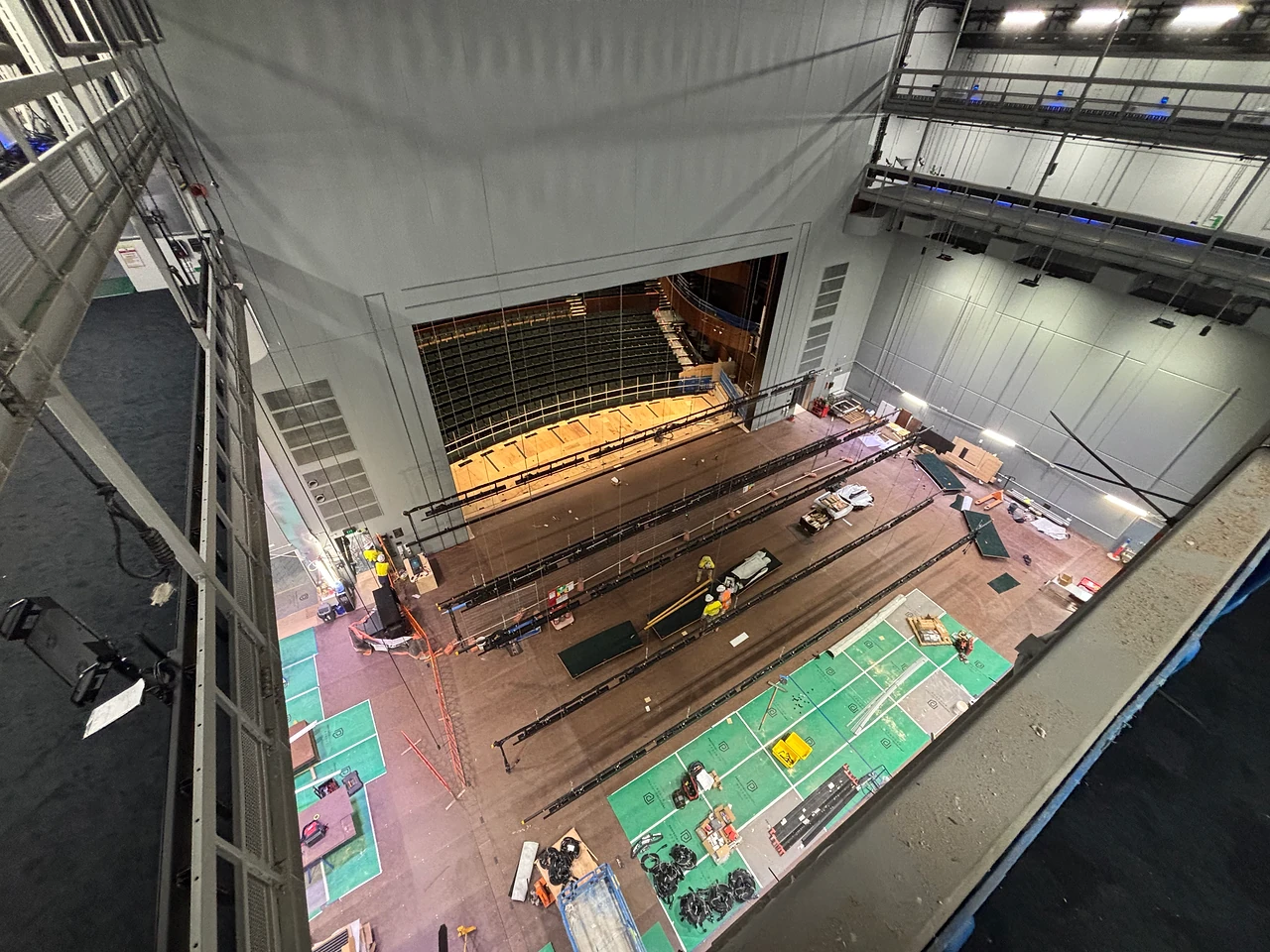 Looking down the fly tower onto lighting bars and cable runs laid out across the stage floor