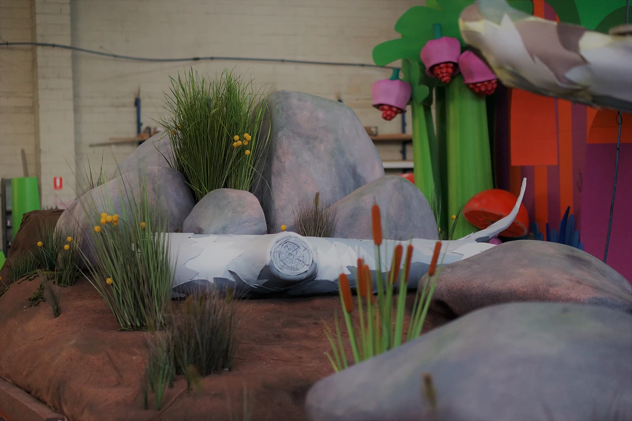 Painted rock formation with grasses and yellow billy buttons on a float