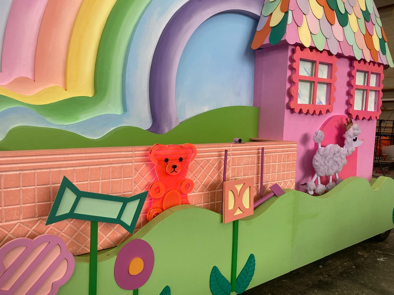 Cottage float side with a pink brick wall, bear and poodle cut-outs