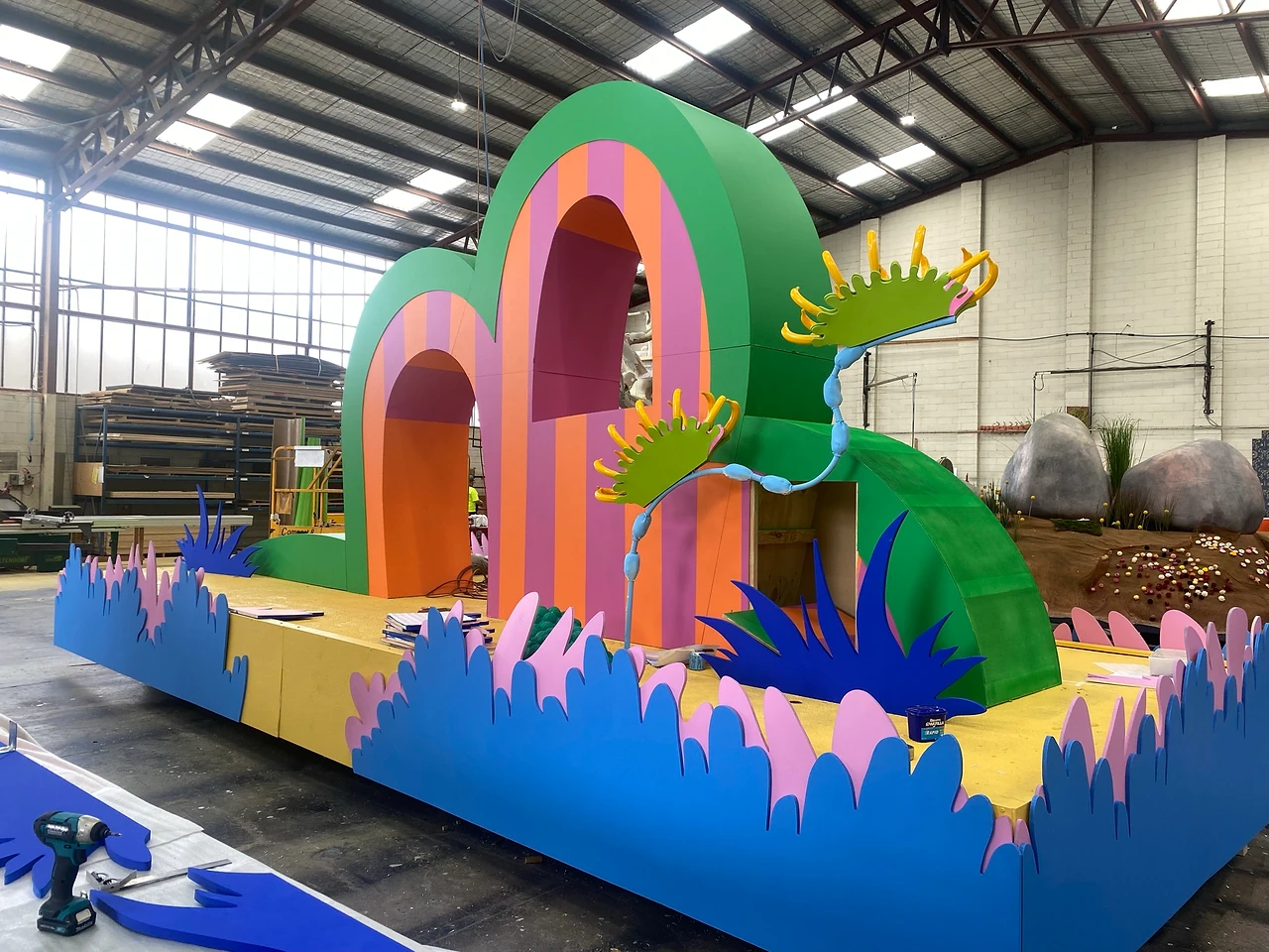 Striped orange and green arch float with blue grass border and venus flytrap plant