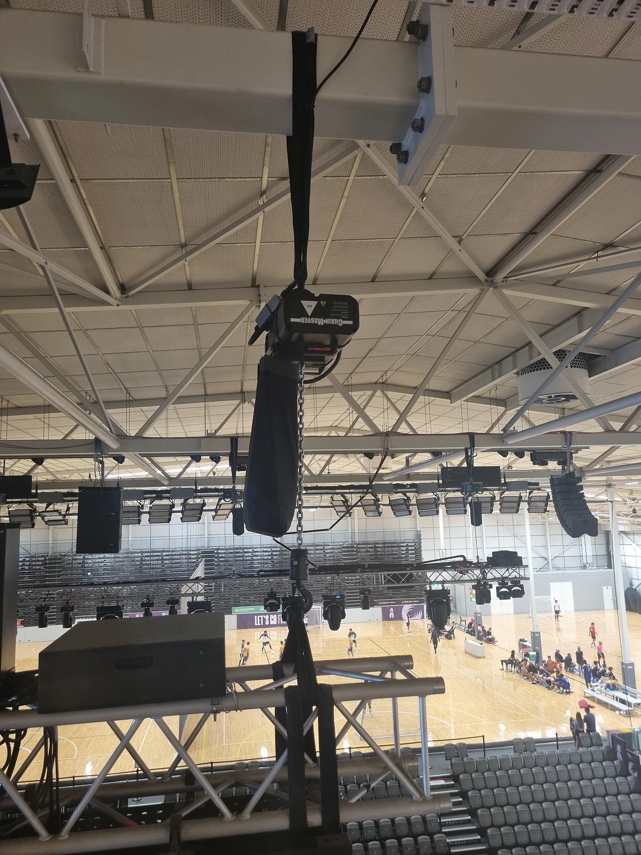 Chain hoist and truss hanging in the arena roof with the court below