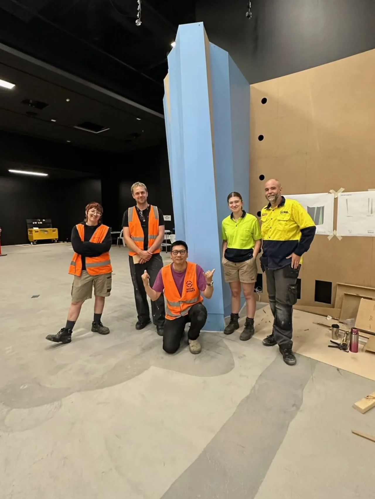 Show Works (now TSA) crew in hi-vis standing beside a tall ice-blue form during the gallery install. Design: Museums Victoria design department. Photo: Show Works (now TSA).