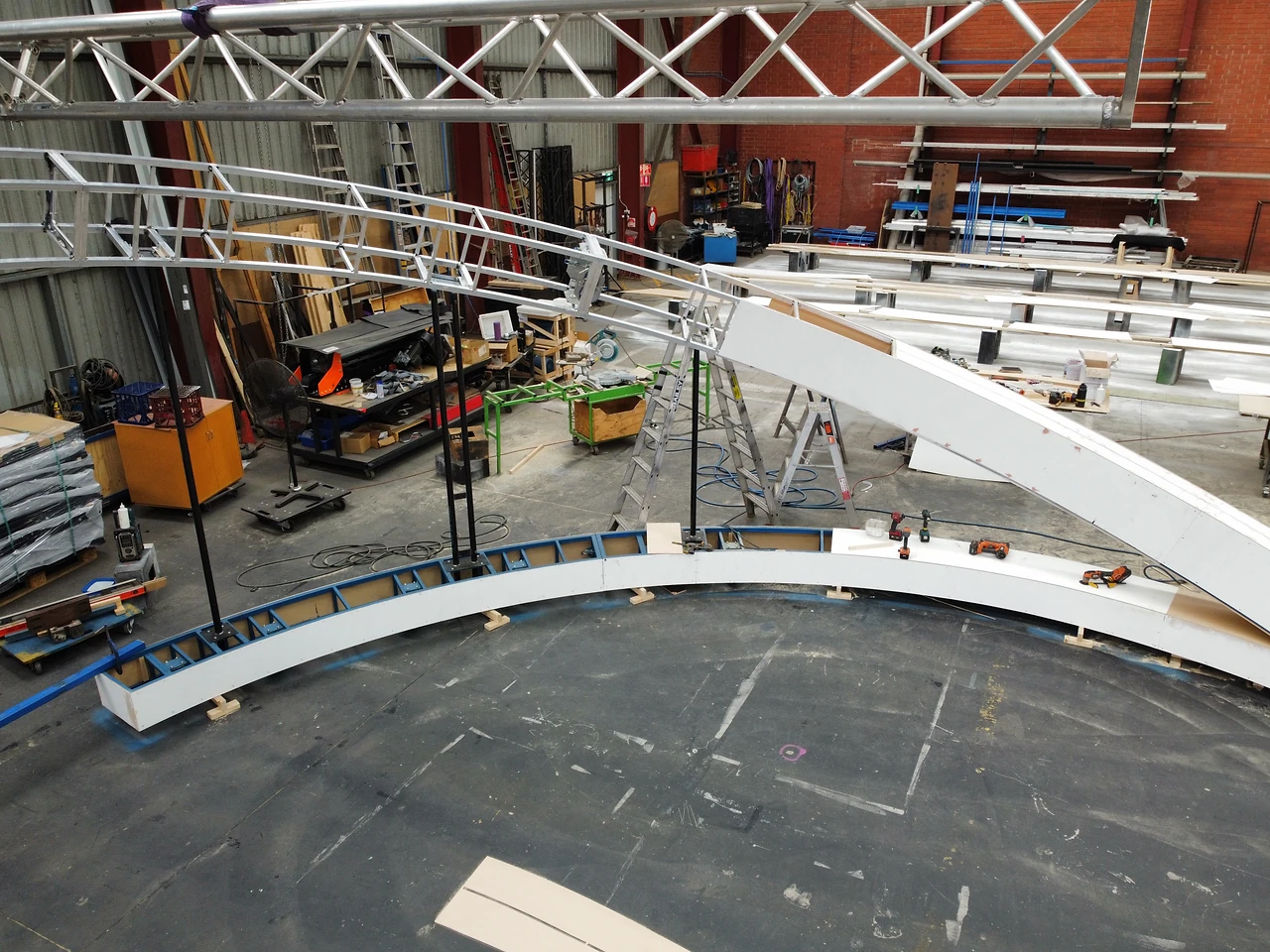 Large curved white arch segment angled up from the base ring during assembly