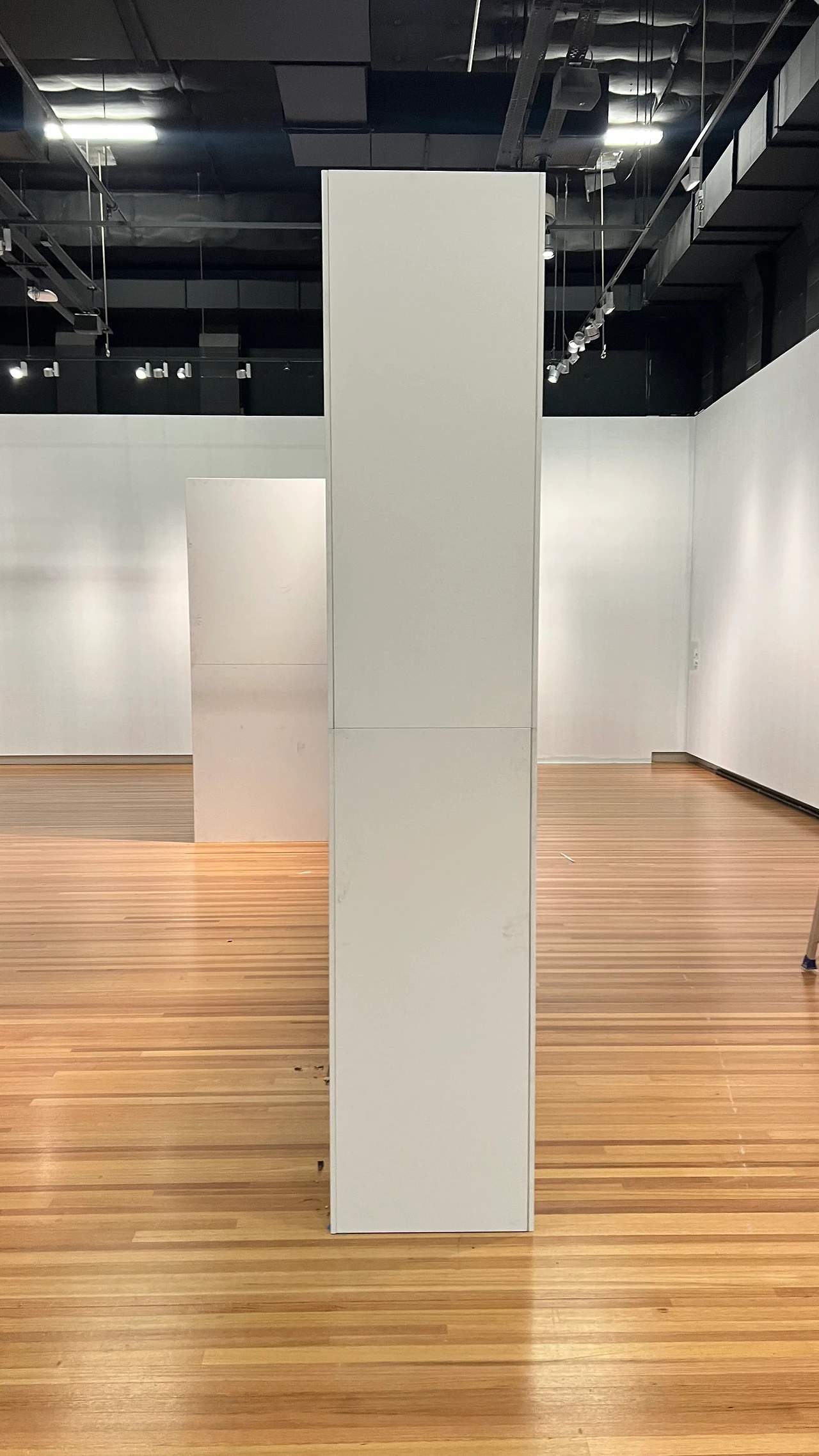 Tall freestanding wall section standing in the open gallery hall with timber floor and track lighting. Design: Tim Blaikie, TSA. Photo: TSA.