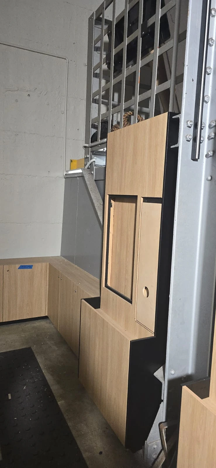Modular timber display panels leaning against a steel grid wall before installation