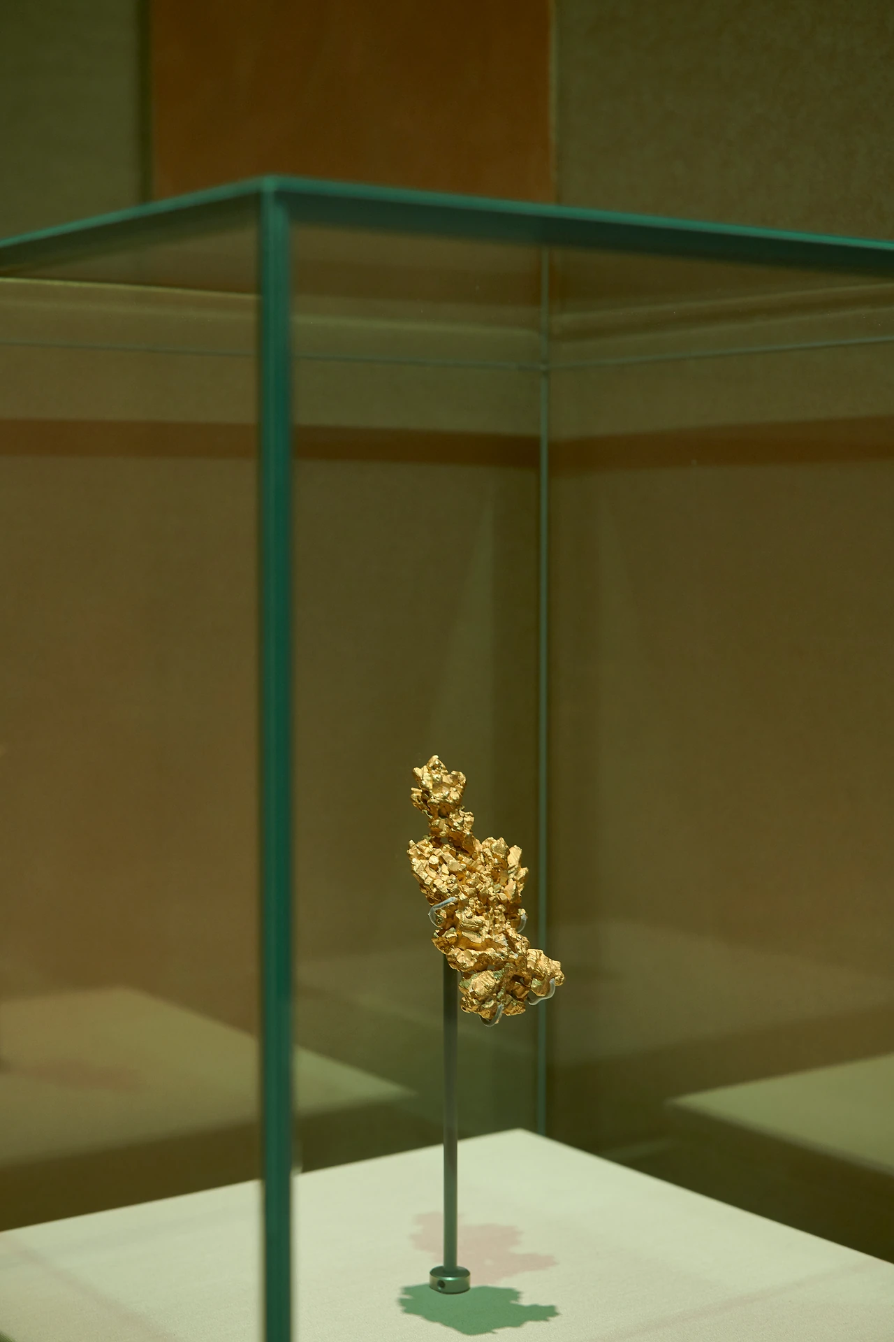 Latrobe gold nugget on a slender stand inside a tall glass case, Treasures of the Natural World, Melbourne Museum. Design: Studio Peter King. Photo: Eugene Hyland.