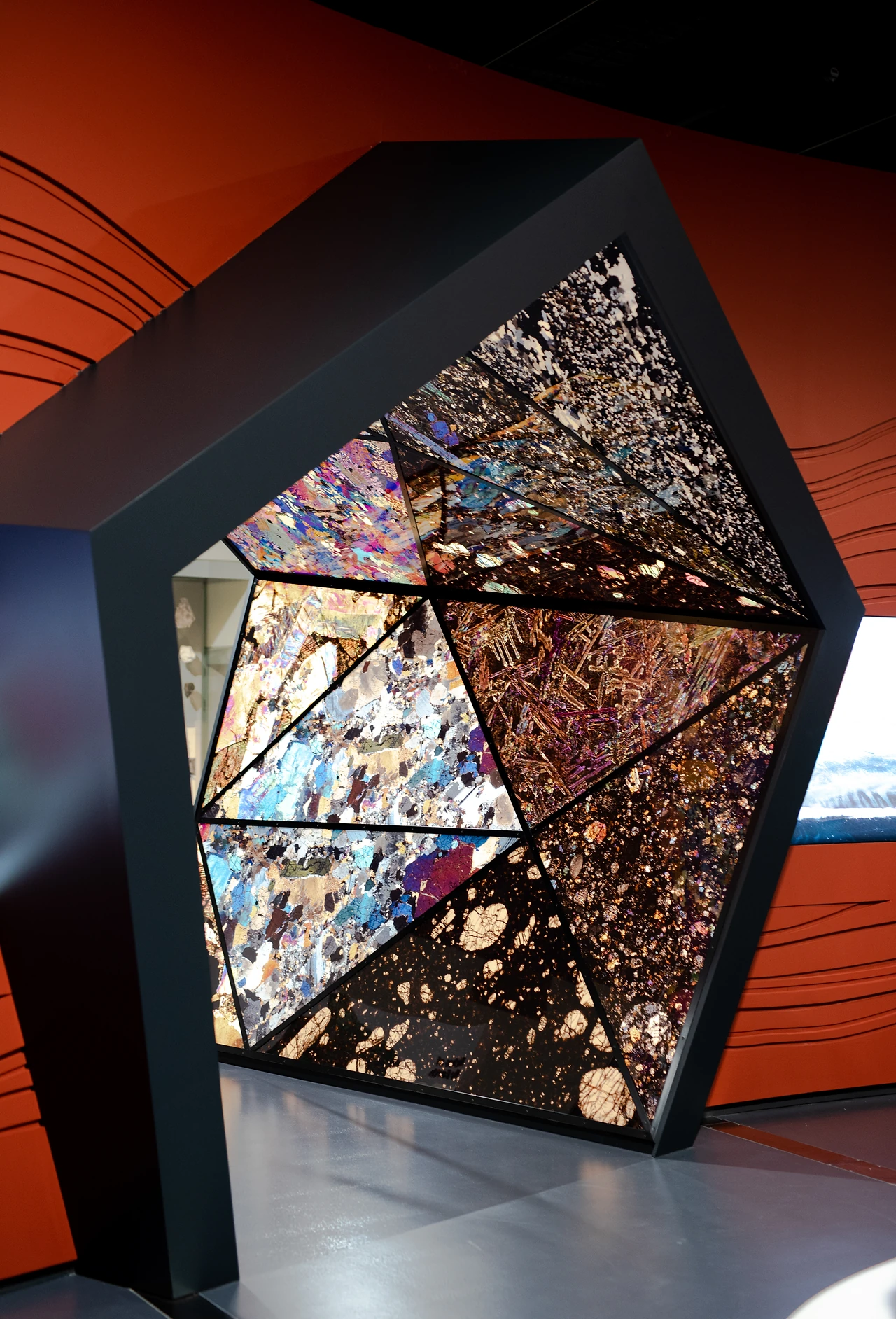 Faceted crystal portal in the Origins gallery, a pentagonal lit frame set into an orange scenic wall. Design: Thylacine Design with Iredale Pedersen Hook architects. Photo: Michelle Sammut.