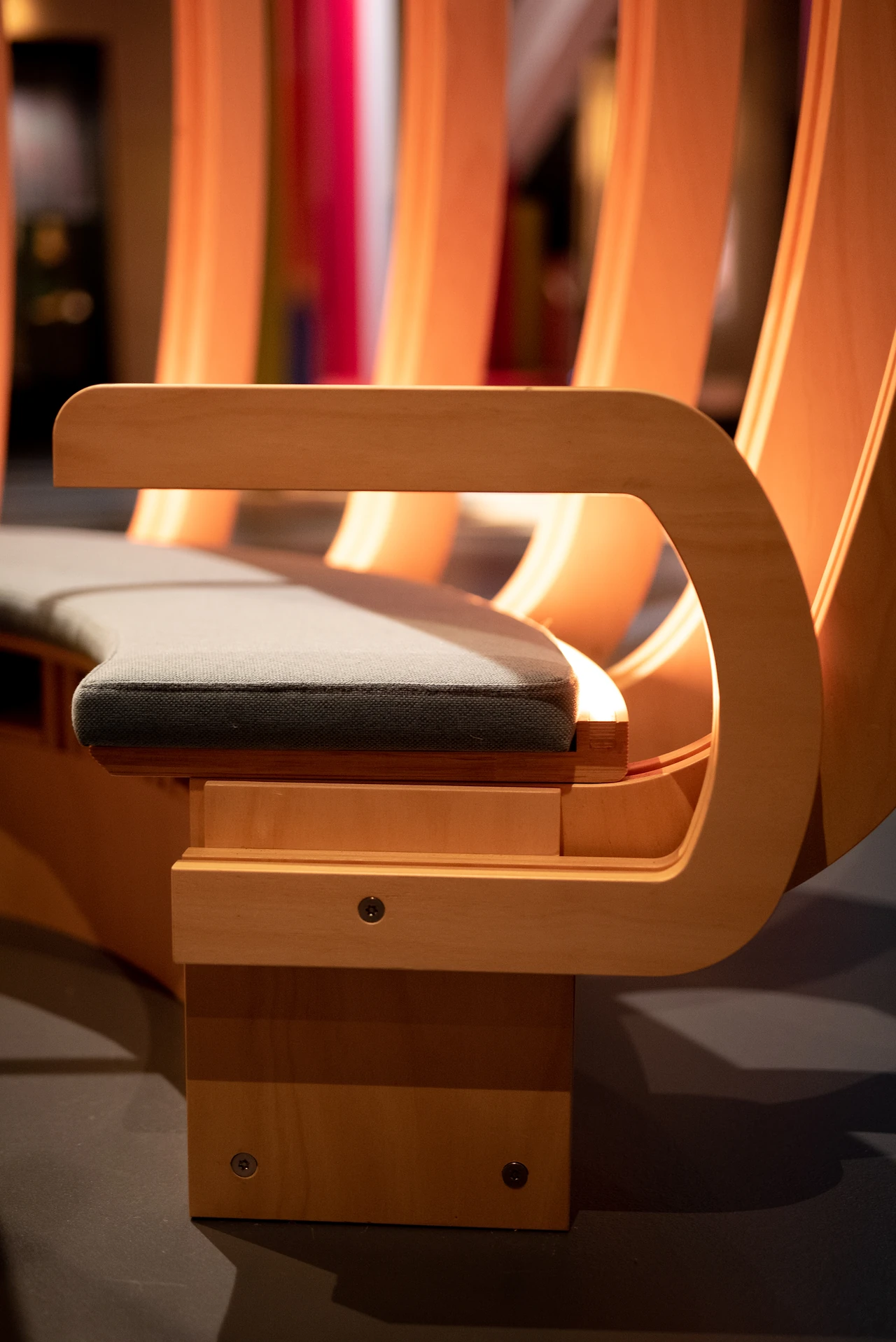 Close view of an upholstered timber bench with a curved rib arm in the Ngalang Koort Boodja Wirn gallery. Design: Thylacine Design with Iredale Pedersen Hook architects. Photo: Michelle Sammut.