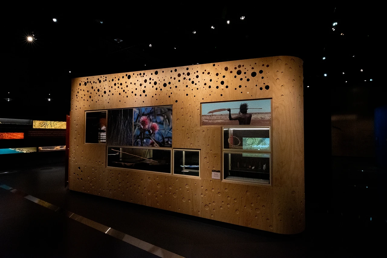 Timber feature wall with a perforated pattern and inset screens and showcases in the Changes gallery. Design: Freeman Ryan Design. Photo: Michelle Sammut.