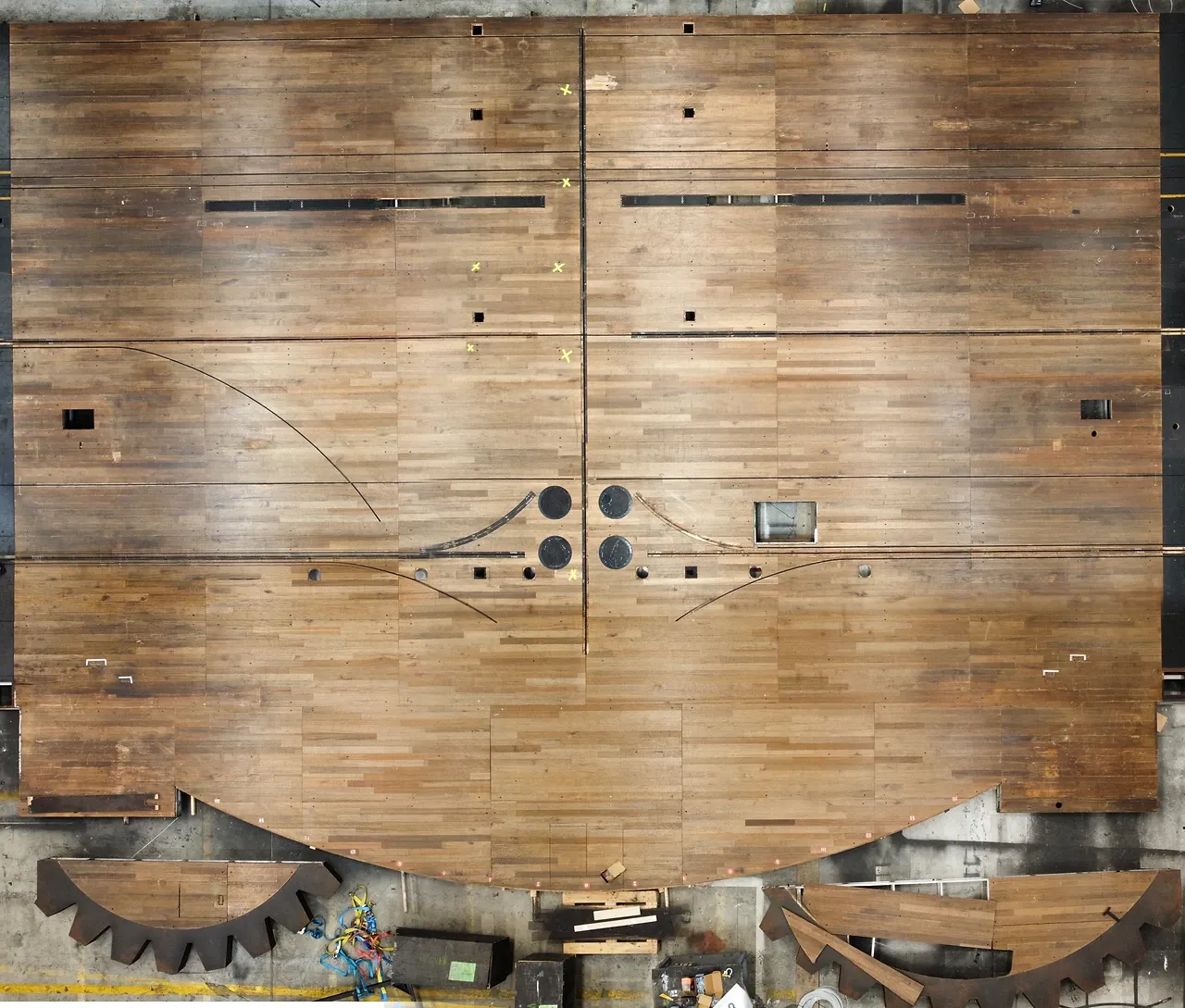 The worn Wicked show deck laid out in the TSA workshop before refurbishment, its gear-tooth scenic segments seen from above.