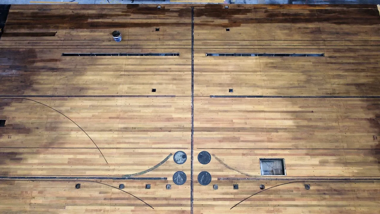 The Wicked show deck part-stained in the workshop, dark finish advancing over raw sanded timber with the automation tracks reading through.
