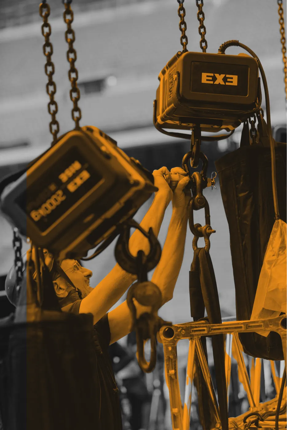 Riggers handling an EXE chain hoist and load chain