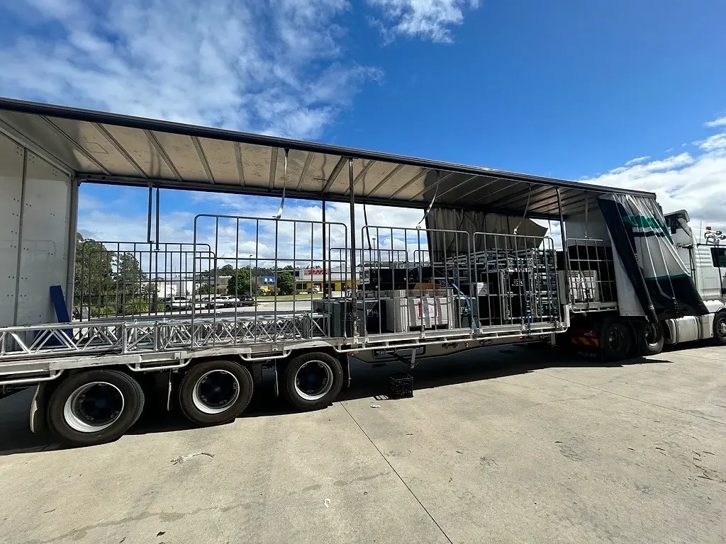 A curtain-sider semi loaded with truss and staging cages